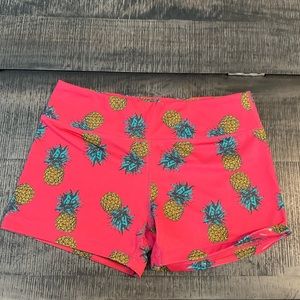 IABMFG. I Am Becoming women’s spandex shorts in hot pink with pineapple print.